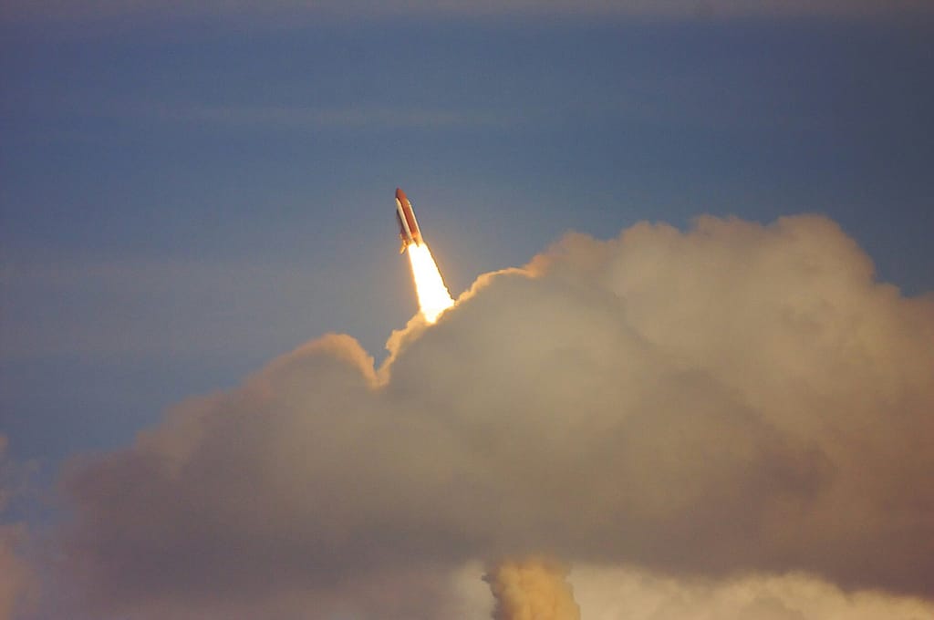 Shiny 3D Rocket Launching Through Colorful Clouds