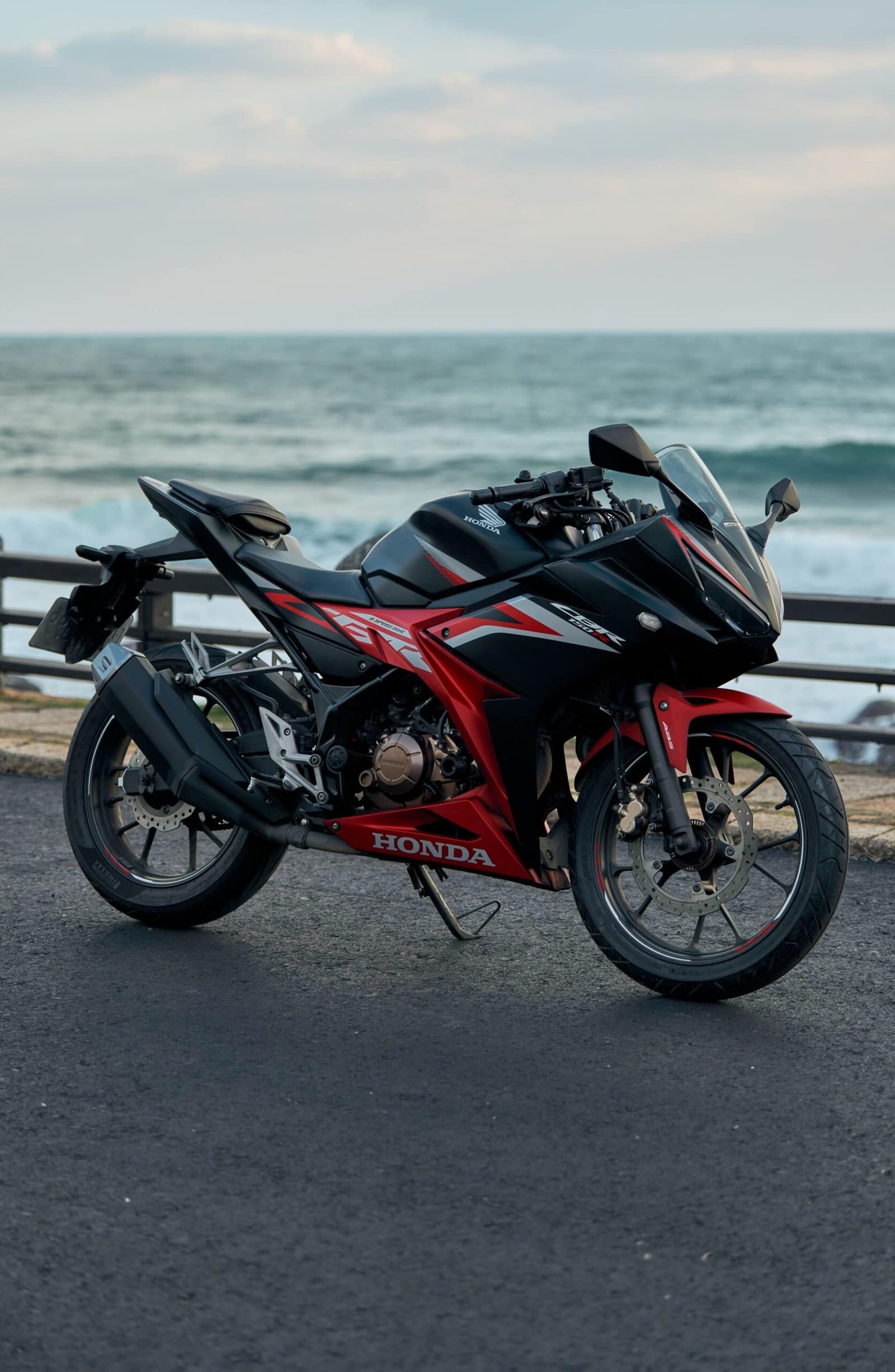 Red Sport Bike on Coastal Road at Sunset