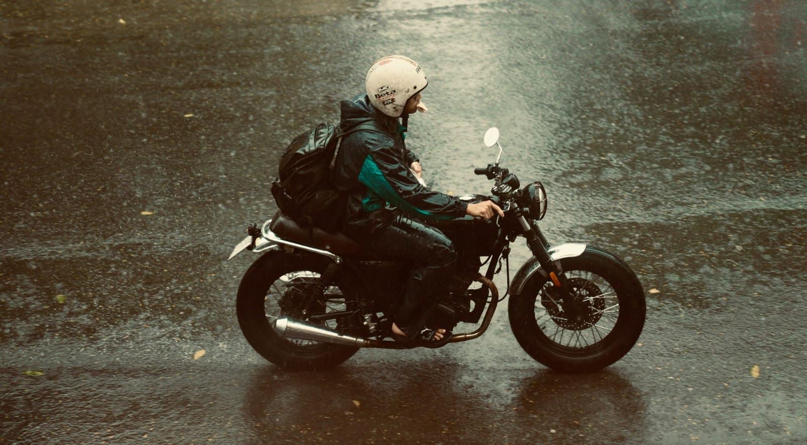 Black Motorcycle Riding Through Rainy Night Street