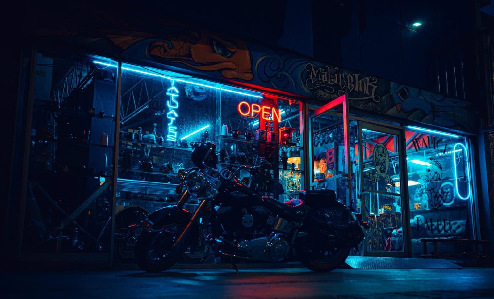 Vintage Motorcycle Parked Under Neon City Lights
