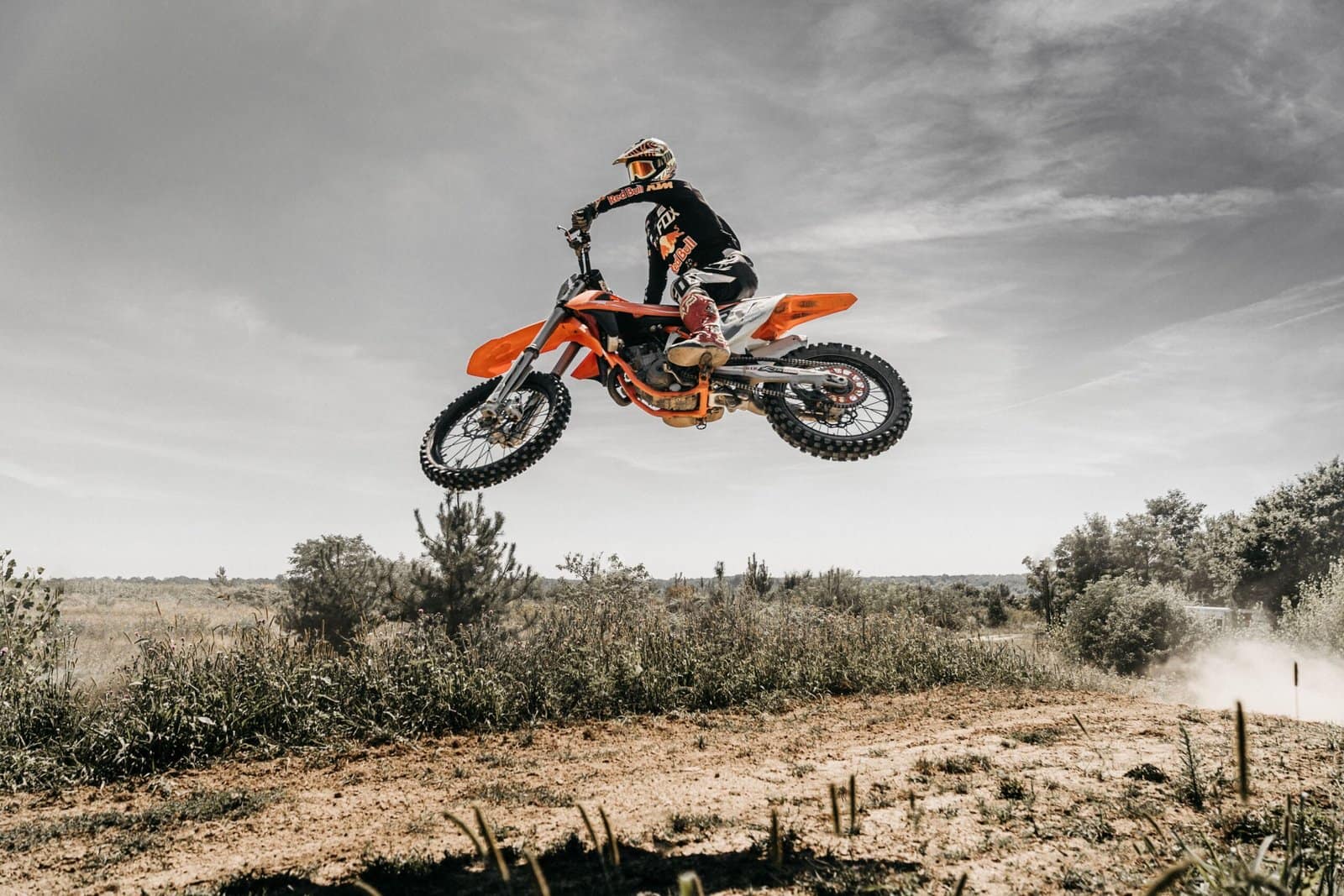 Orange Dirt Bike Jumping Over Sandy Hill