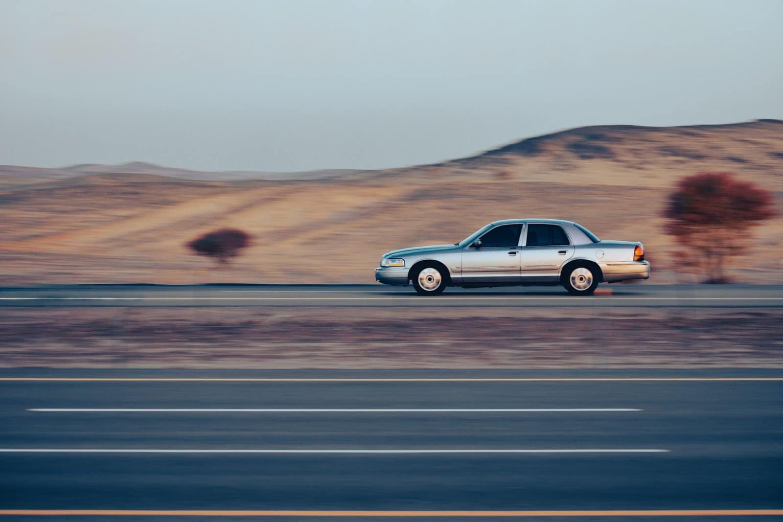 Silver Sports Car Speeding Through a Desert Highway