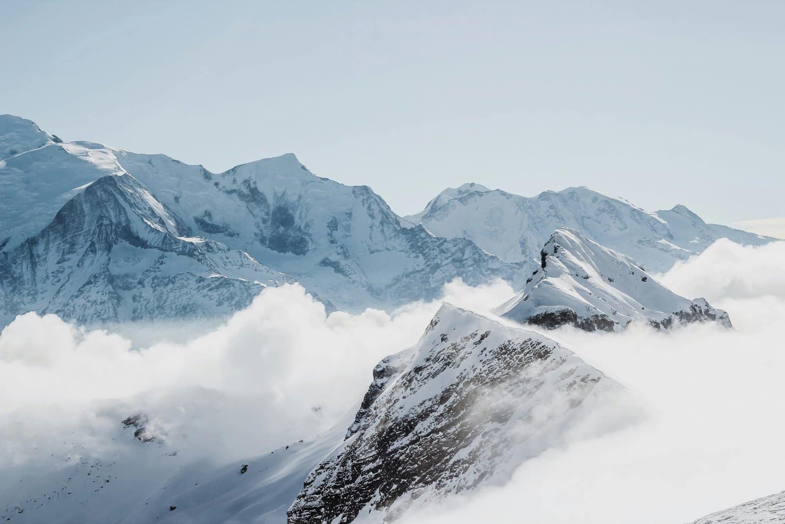Snowy Mountain Peak Above Sea of Clouds