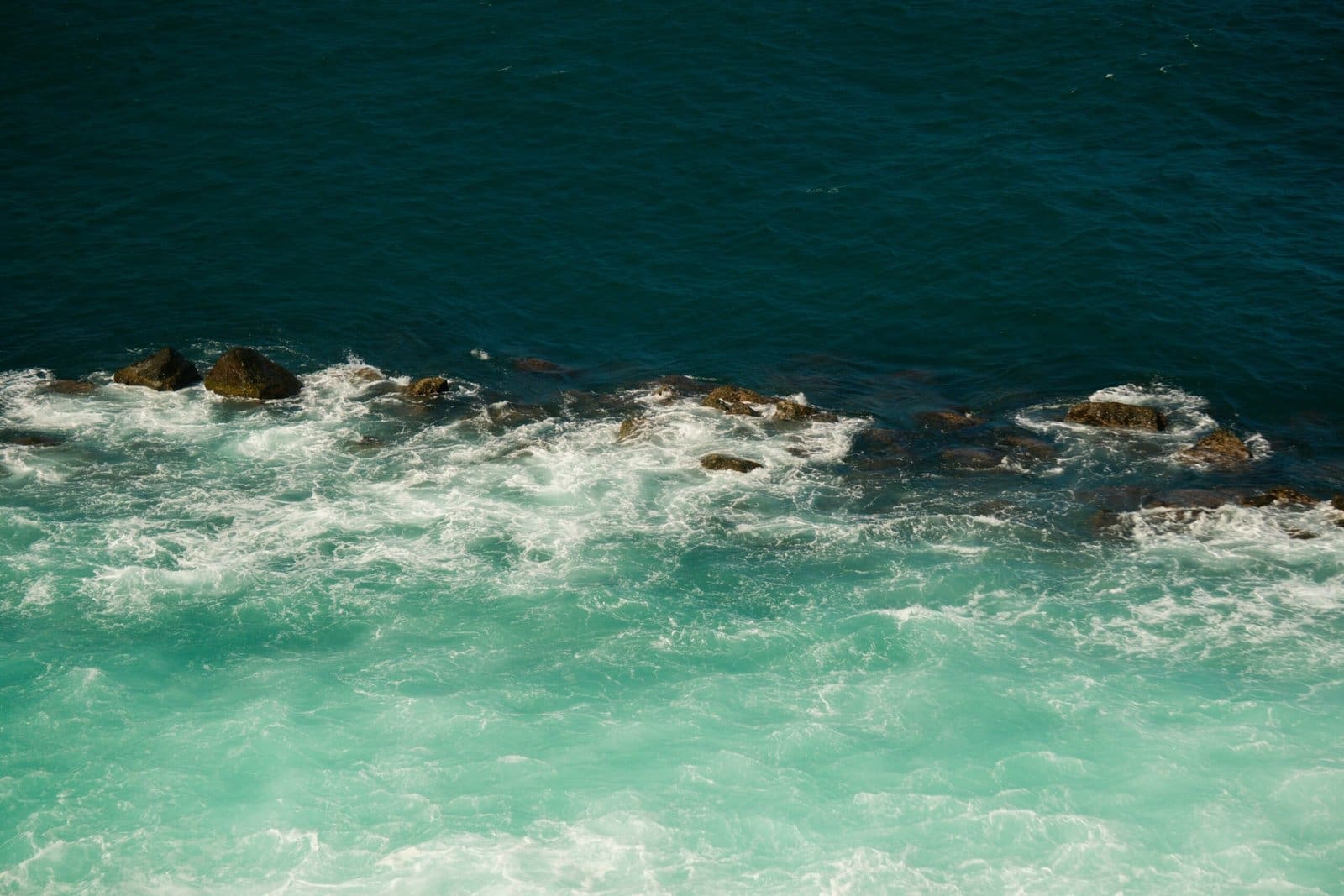 Turquoise Ocean Waves Crashing on Rocky Shore