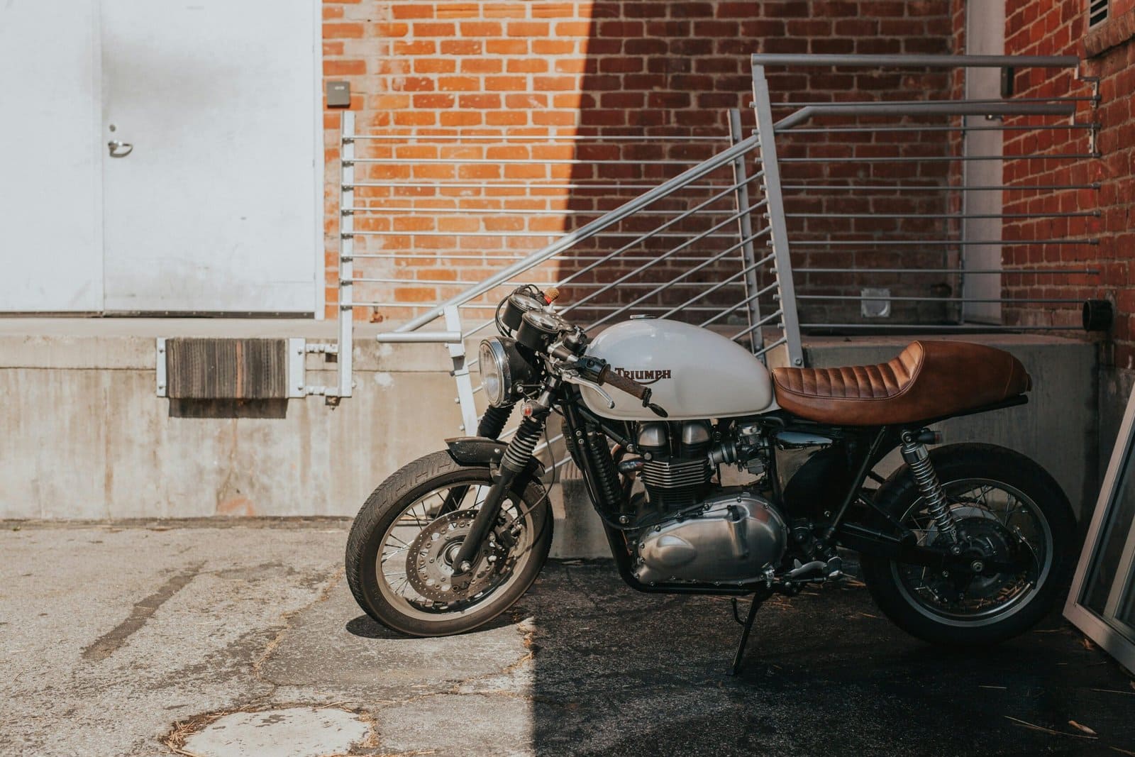 White Cafe Racer Parked Beside Street Railings