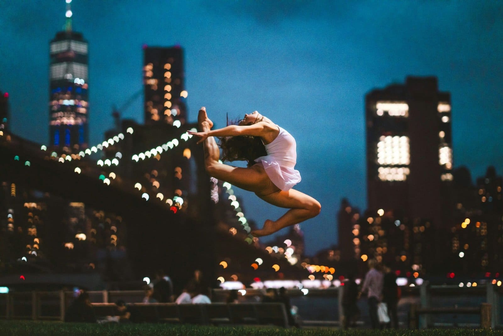 Street Dancer Leaping in City Lights at Night