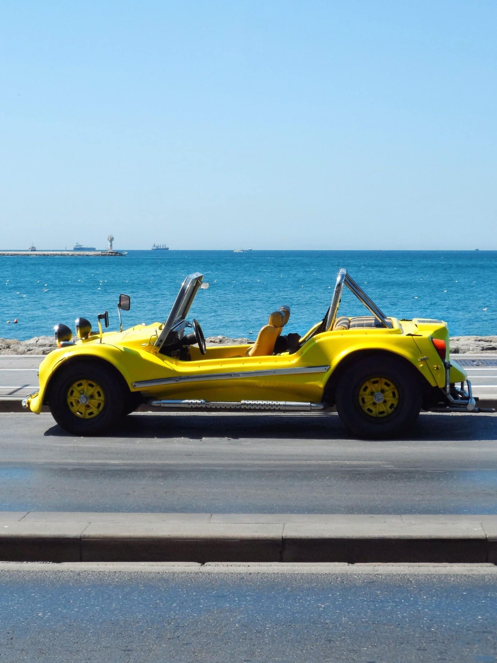 Yellow Convertible Driving Along Beach Road