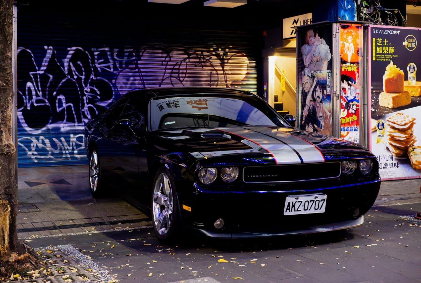 Black Sports Car Parked Under City Lights at Night