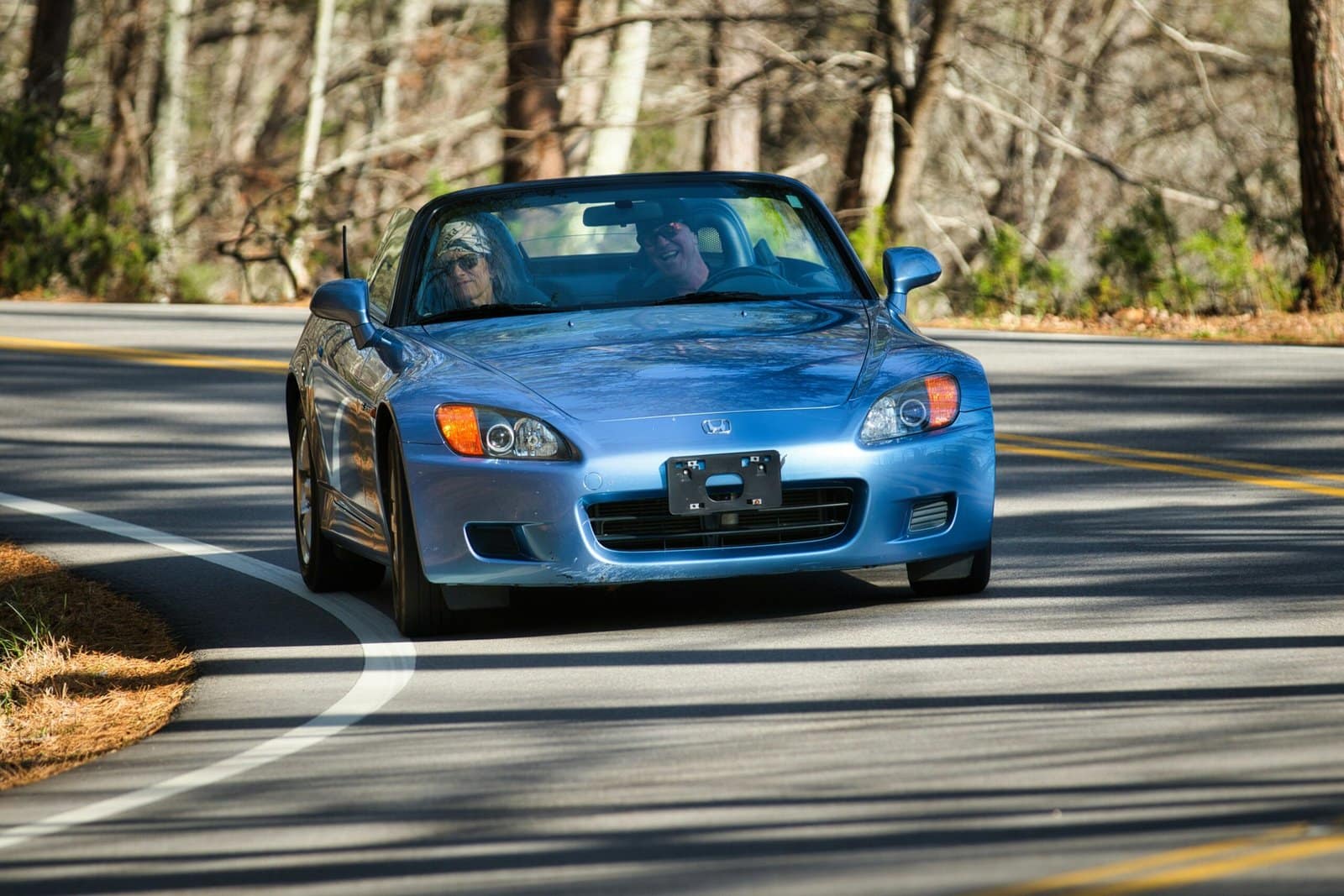 Blue Convertible Cruising Along Winding Road