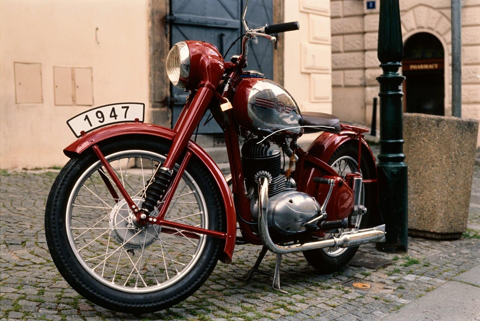 Classic Motorcycle Parked On Rainy Cobblestone Street