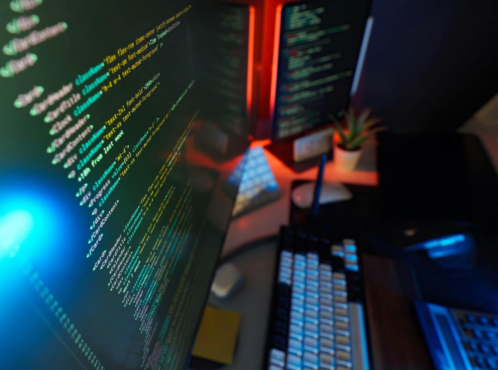 Dual Monitors with Code Glowing in a Dark Office
