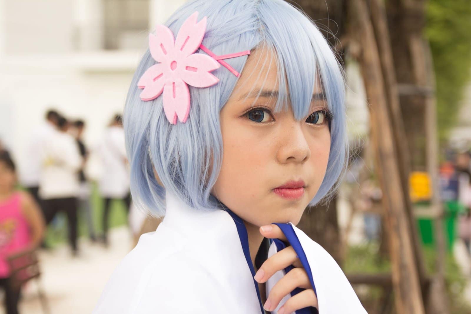Anime Girl Cosplay With Blue Hair and Flowers Outdoors