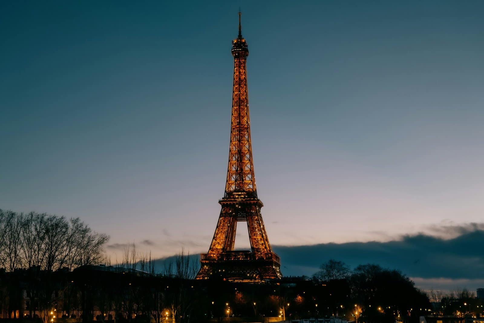 Eiffel Tower Sparkling at Night Over Parisian Rooftops