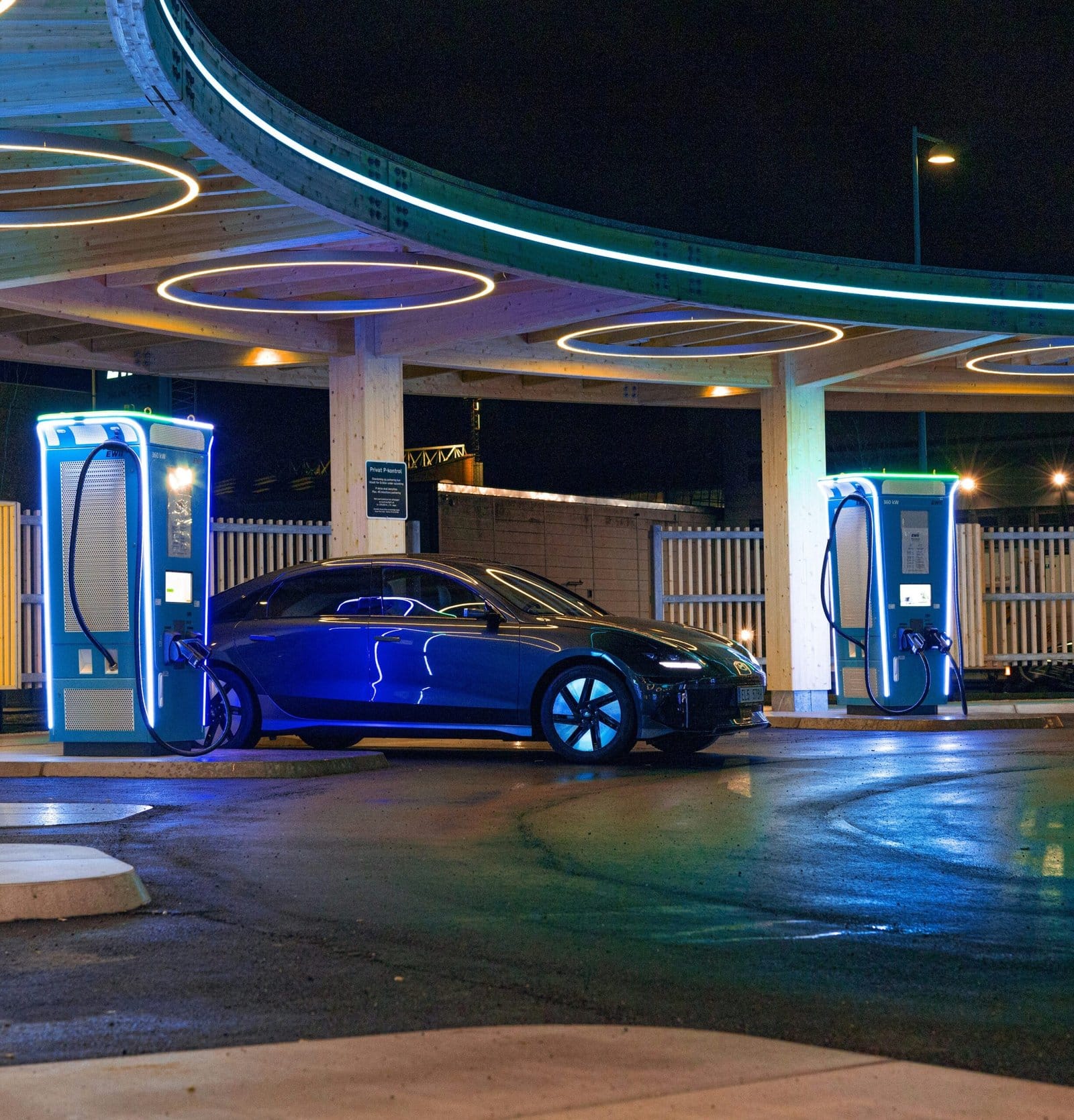 Electric Car Charging At Futuristic Night Station