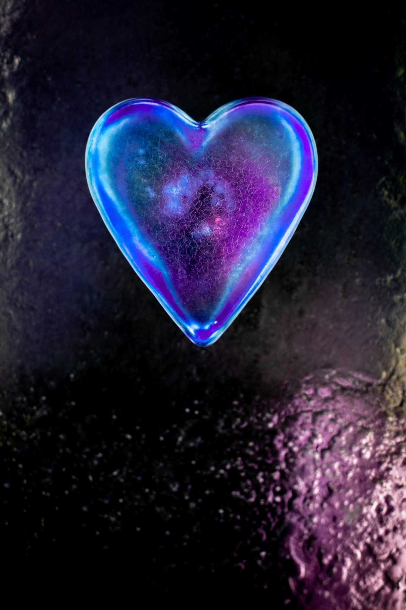 Shiny 3D Glass Heart Floating in Pink Light