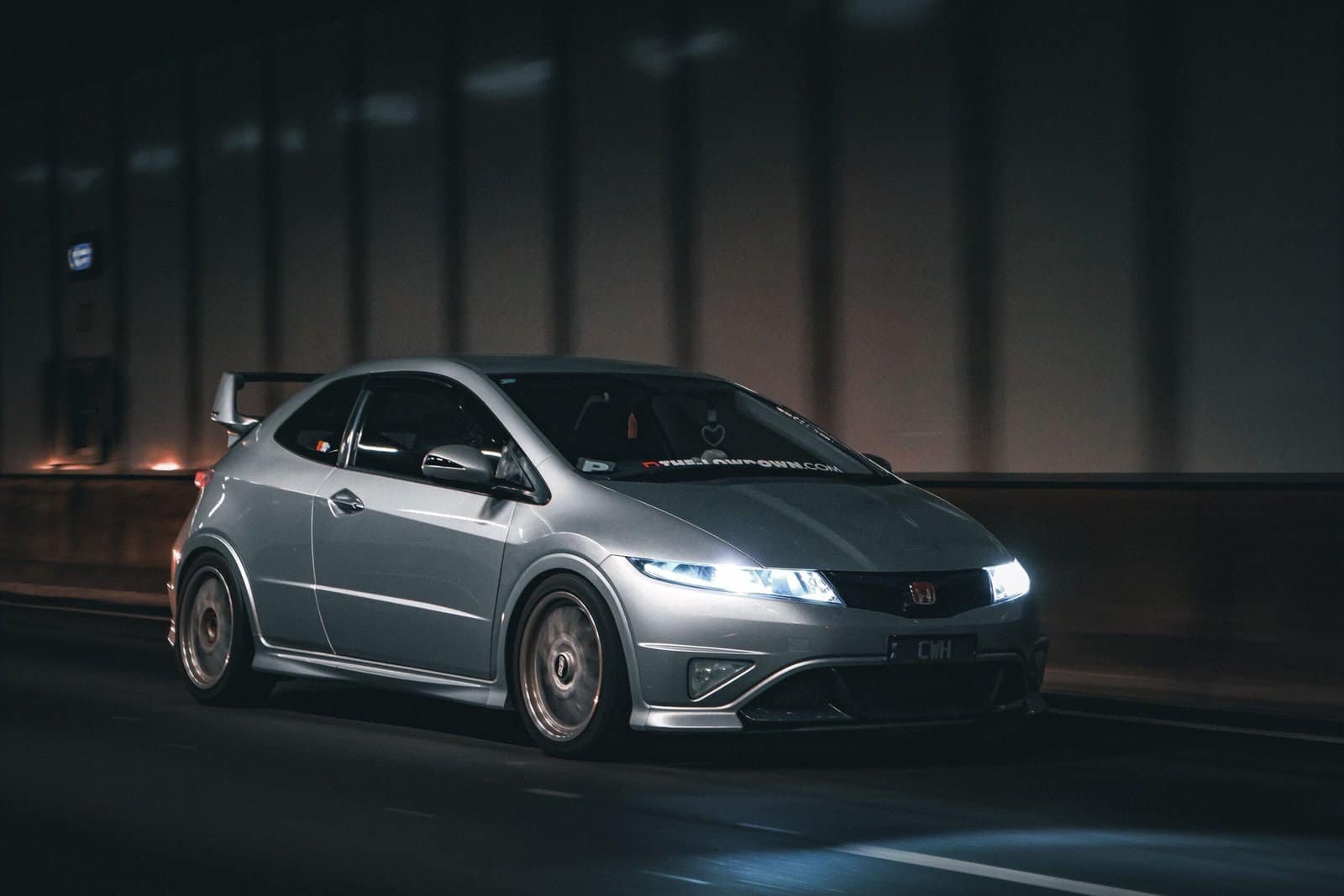 Silver Luxury Car Driving Through City Tunnel at Night